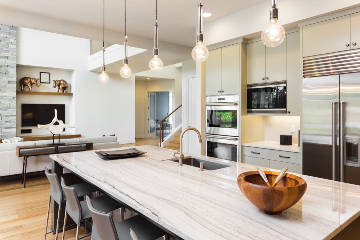 Kitchen with pendant lights over a marble island bench