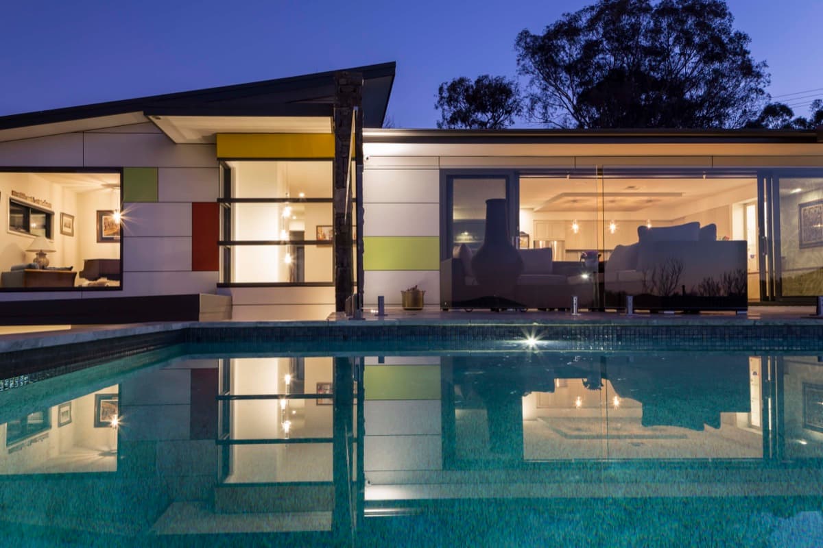 Modern home and pool lit at night