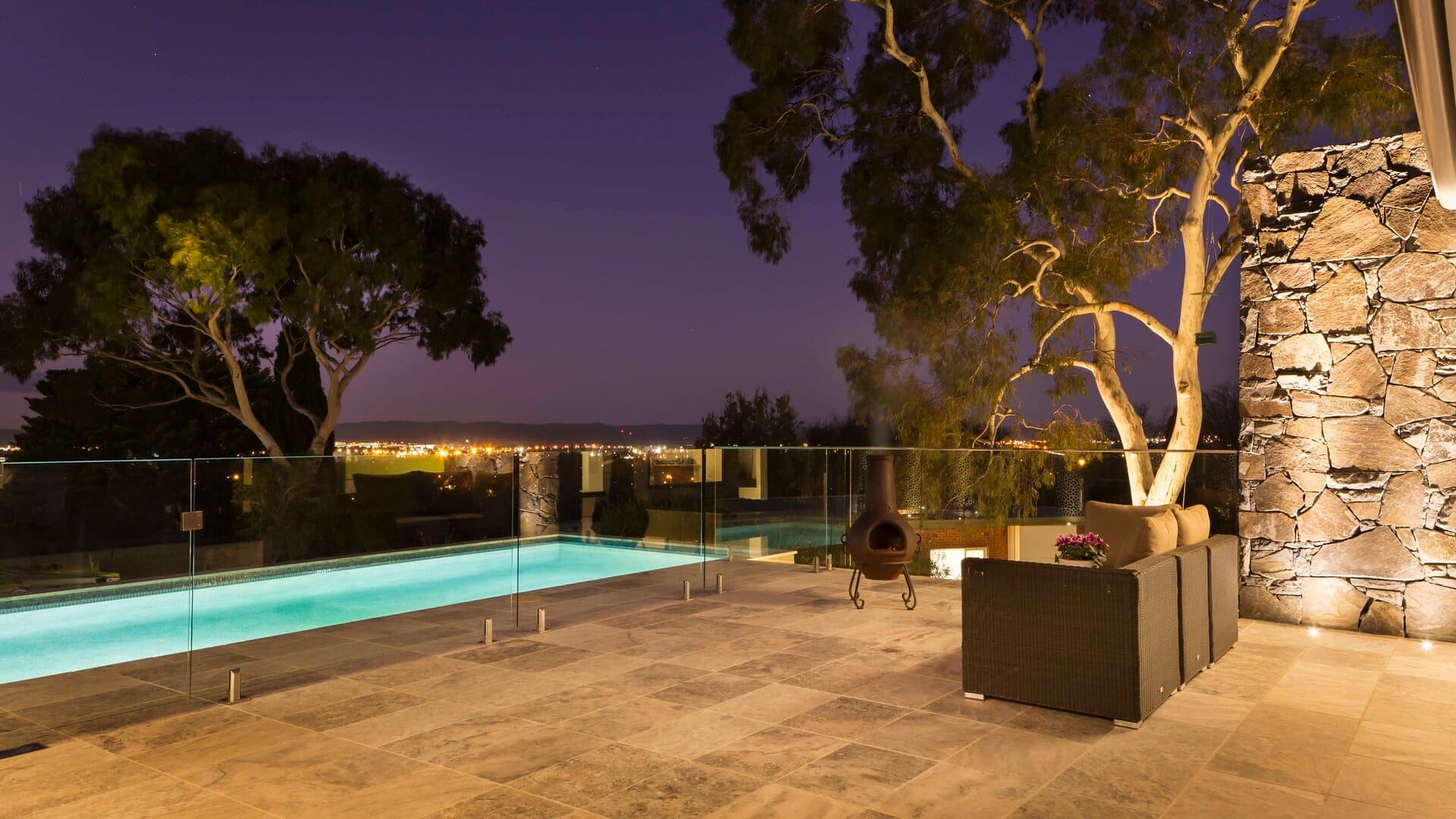 Outdoor pool terrace with landscape lighting at night