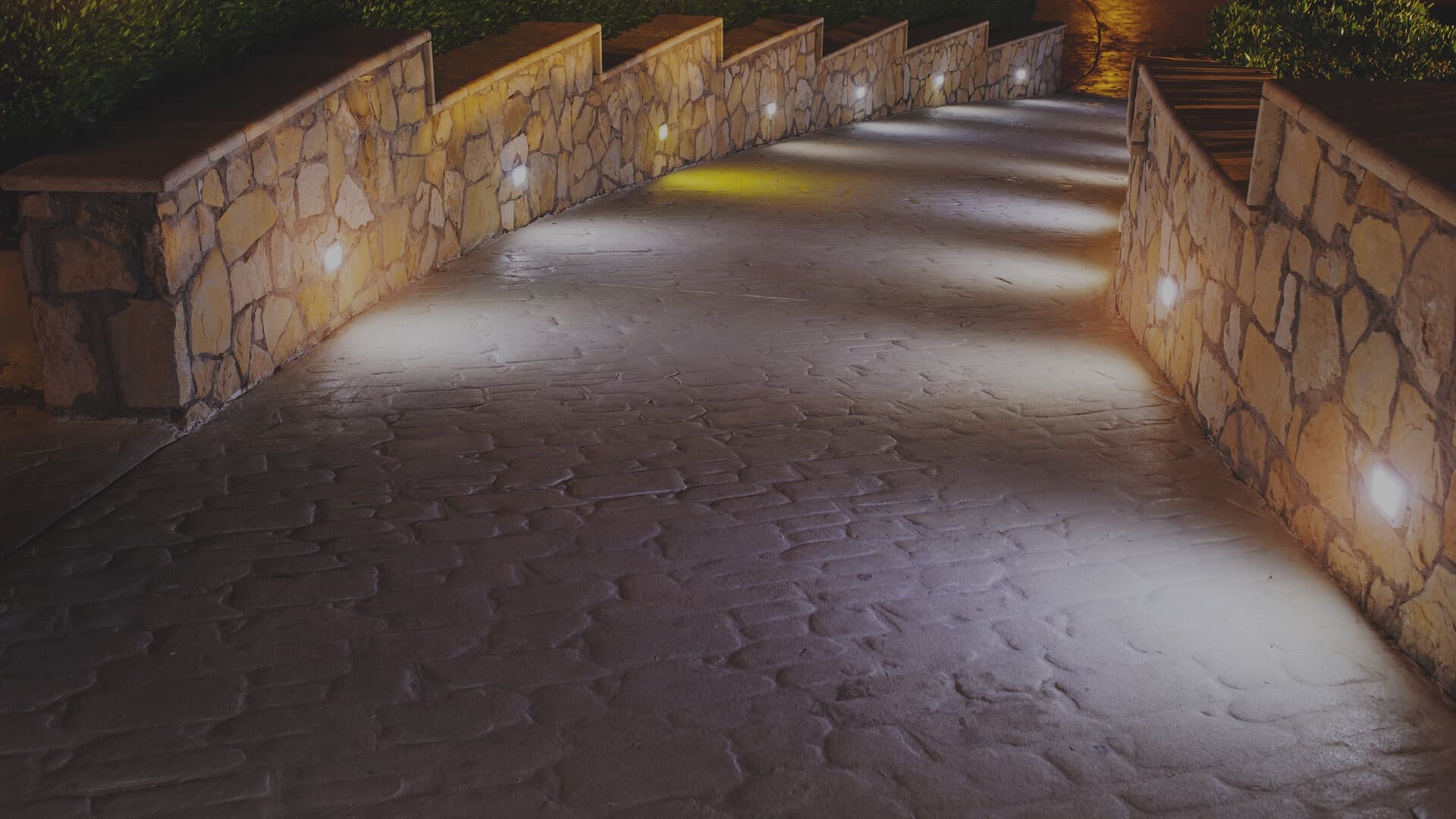 Stone walkway lit by recessed wall lights
