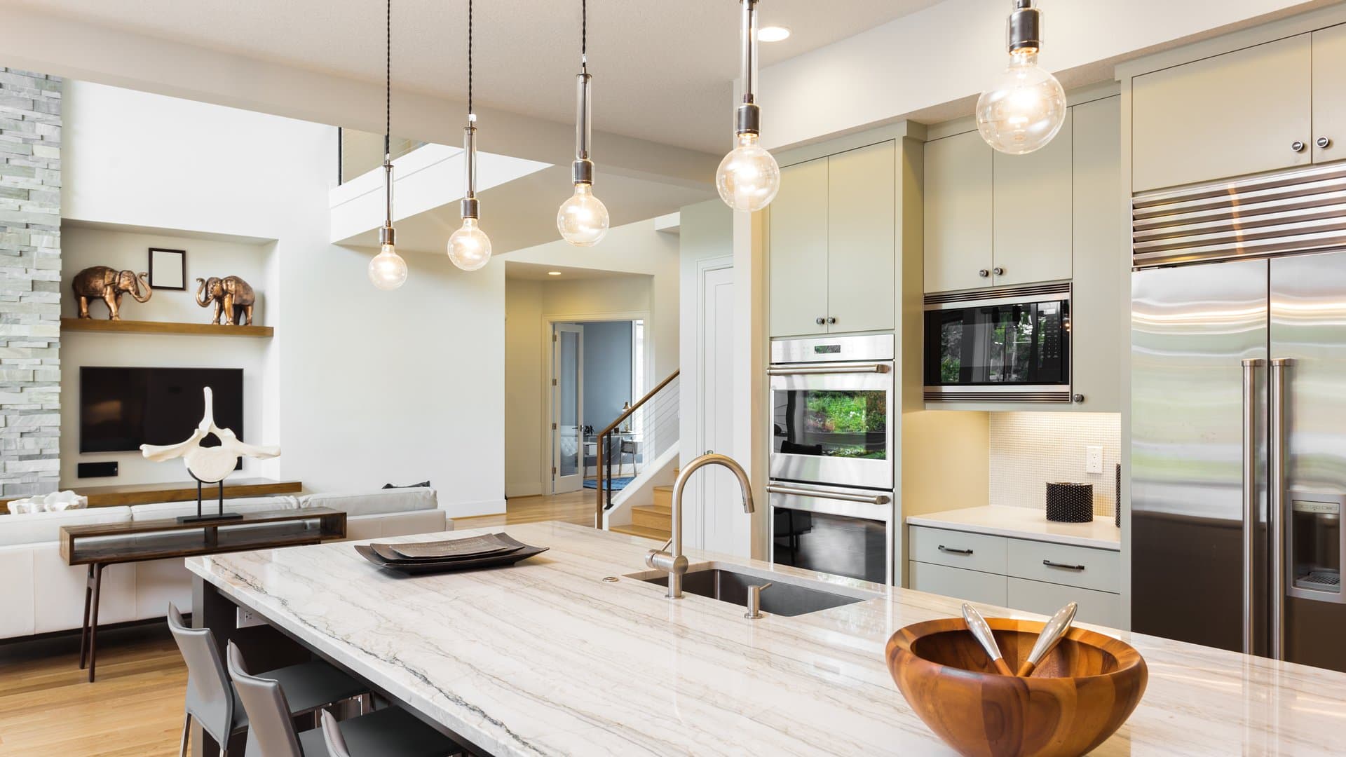 Kitchen with glass pendant lights over a marble island bench